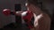Profile of muscular young boxer coach warming up before entering the boxing ring in slow motion -