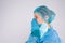 Profile photo. A frustrated young nurse has removed protective mask and pray for life hope. Side space. Gray background.