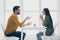 Profile photo of handsome guy and his pretty lady looking tender eyes drinking hot beverage sitting chairs opposite in