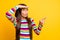 Profile photo of little shocked girl palm brow direct finger look side empty space wear striped shirt isolated yellow