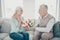 Profile photo of pair aged people anniversary holiday giving big red tulips bunch sitting couch