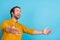 Profile photo of positive hopeful guy look empty space catch hands wear yellow shirt isolated blue color background