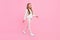 Profile photo of positive nice carefree small lady walk wear dotted shirt pants footwear isolated pink color background