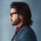 Profile on point. Studio shot of a handsome and dapper young man posing against a grey background.