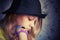 Profile portrait of beautiful blond teenage girl in black hat