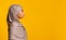 Profile portrait of black muslim woman in hijab over yellow background