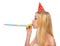 Profile portrait of girl in cap blowing in party horn blower