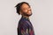 Profile portrait handsome african man with dreadlocks and beard looking at camera with toothy smile, happy and satisfied with life