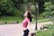 Profile portrait of happy young sporty woman relaxing in park.