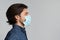 Profile portrait of millennial man wearing protective medical face mask