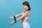 Profile portrait motivated athletic woman doing sports, pumping hands muscles with rubber expander, resistance band for stretching
