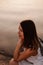 profile portrait of a pretty young woman in the sunset twilight with the sea surface on the background