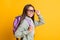 Profile portrait of school person arm touch eyewear carry rucksack isolated on yellow color background