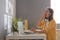 Profile portrait of sleepy woman wearing yellow shirt sitting in her office at workplace and yawning, working on laptop, being