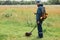 Profile portrait of treasure hunter in meadow, full length portrait of numismatist holding his finding coin under ground in field