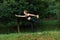 Profile portrait of a young woman in black sportwear in the park doing yoga in the park, trees background