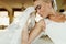 A profile of pretty blond bride holding her forehead while sitting thoughtful