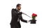 Profile shot of a magician performing a trick with hat and red roses