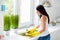 Profile side back rear side photo of positive cheerful girl wash plates use yellow rubber protection gloves sponge stay