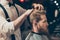 Profile side close up view portrait of handsome virile macho man having his hair cut in barbershop. Fashion hair care concept. Bea