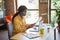 Profile side photo of afro american woman hold documents talk colleagues computer sit desk work in office indoors