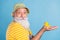 Profile side photo of aged man happy positive smile hold rubber duckling toy isolated over blue color background