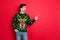 Profile side photo of excited funny man in deer reindeer jumper look point index finger at copyspace isolated over red