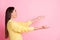 Profile side photo of young beautiful amazed happy shocked girl hold hands catch copyspace  on pink color