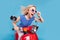 Profile side photo of young excited girl happy positive smile ride bike speed hand touch sunglass isolated over blue