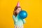 Profile side photo of young little girl blow balloons decoration prepare party isolated over yellow color background