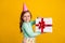 Profile side photo of young small girl happy positive smile receive present box isolated over yellow color background