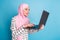 Profile side photo of young woman bite lips amazed browse computer fail mistake wear hijab isolated over blue color