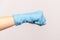 Profile side view closeup of human hand in blue surgical gloves showing boxing fists with hand. attack or defence against problems