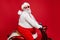 Profile side view portrait of nice bearded cheerful funny funky Santa St Nicholas father riding motor bike delivering