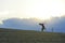 Profile silhouette of young man running in countryside practicing final sprint on sunset