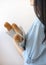 Profile size view, half face cropped vertical photo of young feminine lady in blue shirt hold three baguettes in hands on