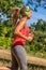 Profile of trendy young woman running listening to music in park