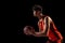 Profile view of basketball player posing with ball isolated on dark studio background. Sport, energy, power, results.