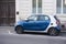 Profile view of blue smart car parked in the street