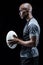 Profile view of confident sportsman holding rugby ball