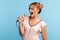 Profile of young adult female wearing summer dress singing loudly in karaoke, talented woman sings favorite song in microphone,