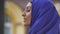 Profile of young beautiful muslim woman in blue hijab with pierced nose looking sideways