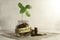 Profit. Glass jar with coins and a plant on the table and several coins nearby.