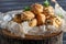 Profiteroles with pasta. On a wooden stand. Sprinkled with white and black sesame seeds. A microgreen of sunflower is decorated.