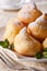 Profiteroles with powdered sugar and mint close up, vertical