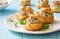 Profiteroles stuffed with cream cheese and mushrooms on blue wooden background