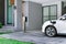 Progressive concept of EV car and home charging station in residential area.