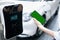 Progressive concept of green screen mockup phone, EV car and charging station.