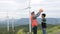 Progressive engineer with his son in the wind farm atop of the mountain.