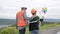 Progressive engineer with his son in the wind farm atop of the mountain.